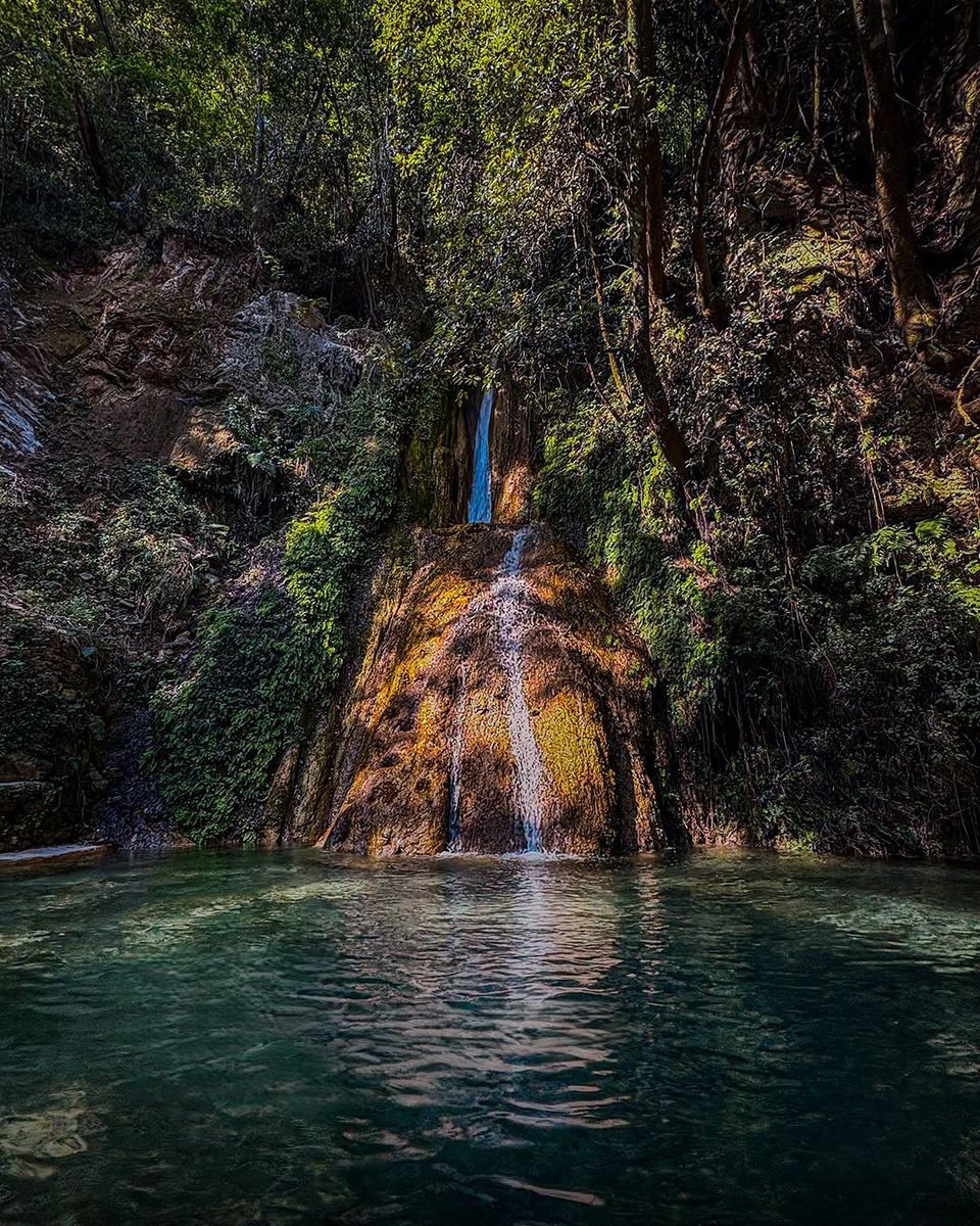 Cascada que cae sobre una poza en la sierra
